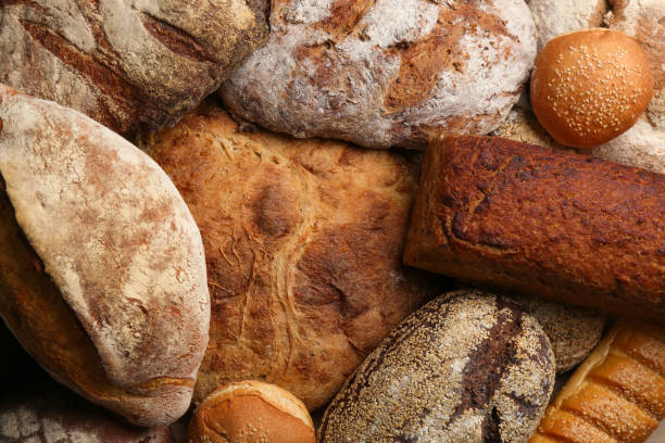 istock Different kinds of delicious bread as background, top view 1364398137