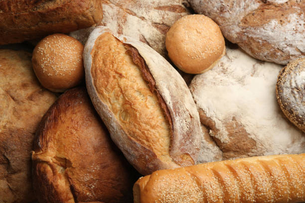 istock Different kinds of delicious bread as background, top view 1364398140