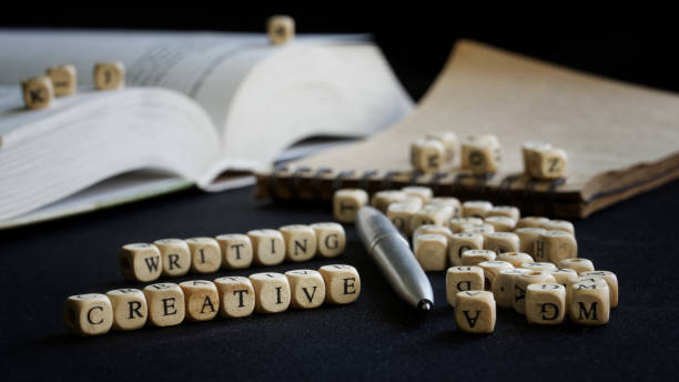 istock Creative writing next to open textbook, notepad and fountain pen. The concept of teaching creative writing in college and university. Selective focusing 1364398363