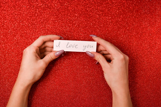 women's hands hold a note with the text - I love you