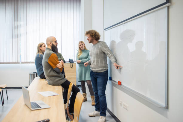 istock Male student explaining the assignment to his colleagues on whiteboard 1364400645