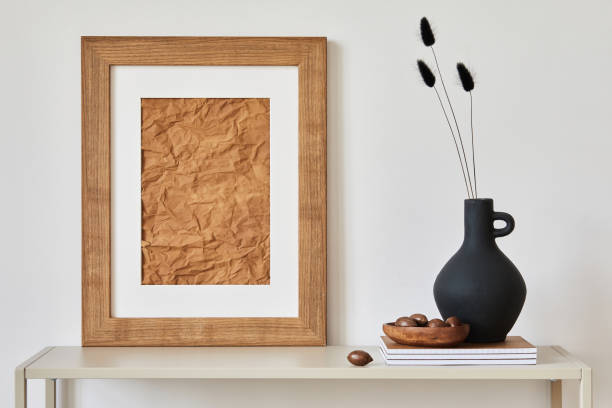 istock Minimalist composition of living room interior with mock up poster frame, beige commode, vase and personal accessories. Copy space. Template. 1364400853