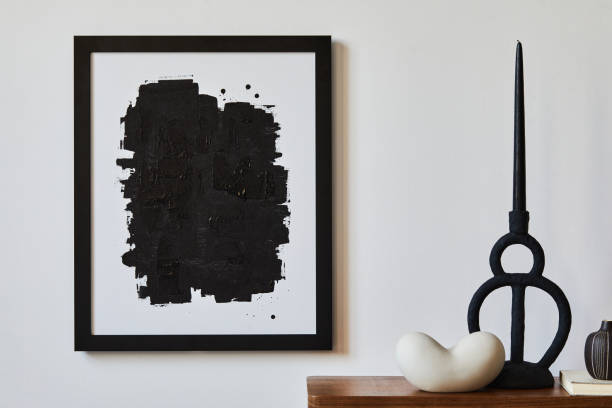istock Creative composition of minimalist living room with mock up poster frame, wooden commode, candlestick and personal accessories. Copy space. Template.
