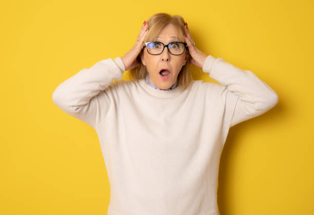 Elderly amazed woman in glasses open mouth gawp look at camera feels stunned isolated on yellow background Elderly amazed woman in glasses open mouth gawp look at camera feels stunned isolated on yellow background gawp stock pictures, royalty-free photos & images