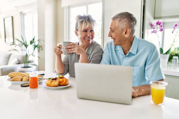 istock Senior caucasian couple having breakfast using laptop at the kitchen. 1364402789