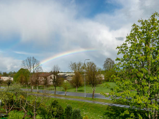 istock colorful landscape with a rainbow over the trees, a small village view 1364403117