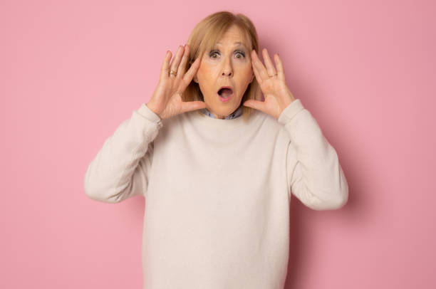 Elderly amazed woman in glasses open mouth gawp look at camera feels stunned isolated on pink background Elderly amazed woman in glasses open mouth gawp look at camera feels stunned isolated on pink background gawp stock pictures, royalty-free photos & images
