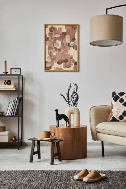 istock Modern living room interior composition with mock up poster frame, beige sofa, black metal shelf and small home decorations. Creative home staging. White wall. Copy space. Template. 1364405699
