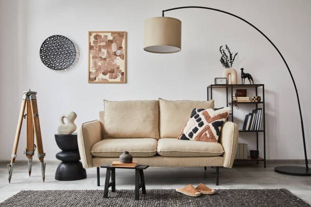 istock Creative composition of modern living room interior with mock up poster frame, beige sofa, side table and stylish small personal accessories on metal shelf. Copy space. Template. 