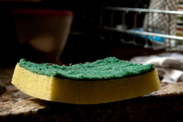 Dish sponge over the sink with the green side up. Home cleaning concept. sponge concept.
