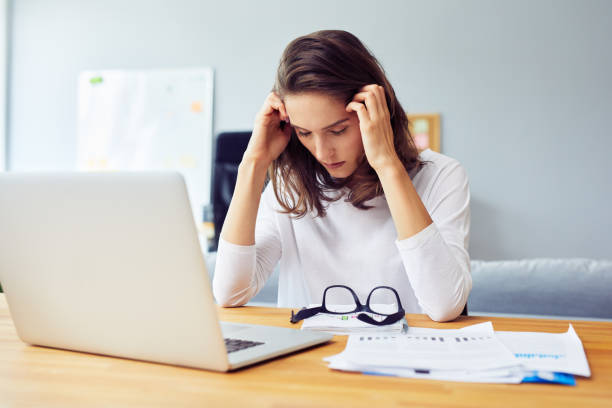 istock Stressed young woman sitting at desk working from home office 1364408422