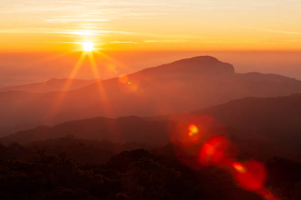 The sun rising over mountains on a winter day. The glowing sun rising over mountains range on a cold winter day, the landscape of mountains on the morning mist. Inspiration, positive thinking concepts. Soft focus. mountain sunrise stock pictures, royalty-free photos & images