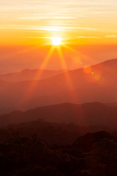 the sun rising over mountains on a winter day. - sunset sun mountain sunrise imagens e fotografias de stock