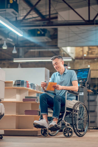 man in wheelchair taking out postcard from envelope - for sale classified ad newspaper sale imagens e fotografias de stock