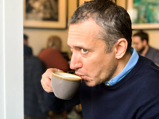 istock Man is drinking coffee in cafe by the window 1364411116