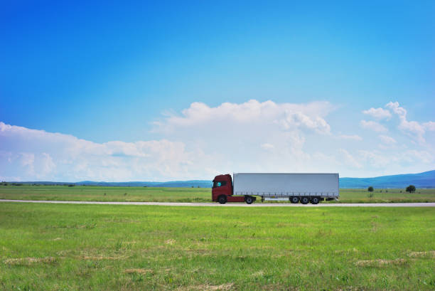 Side view of a semi truck and trailer on the road.