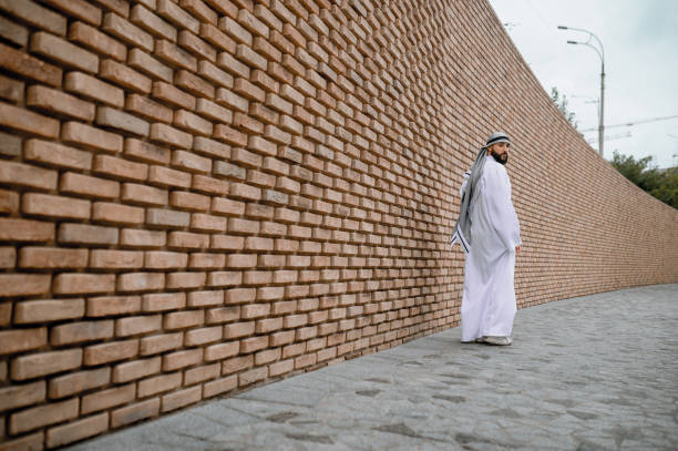 istock Man in white long thobe on a brick wall background 1364413649