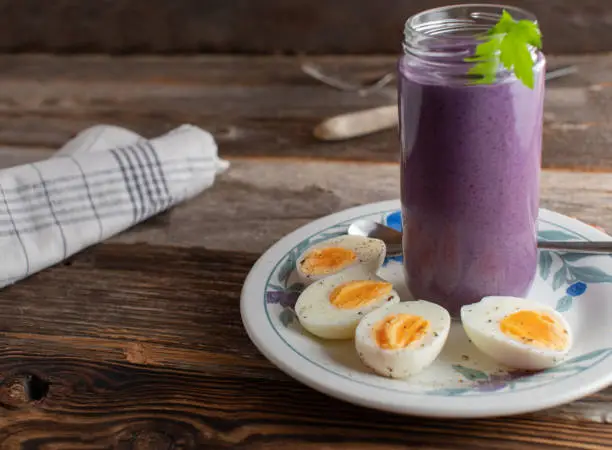 Homemade low carb or ketogenic breakfast with a healthy berry smoothie and boiled eggs