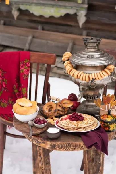Festive decor for Maslenitsa on the table: pancakes, bagels, a samovar. Russian folk traditions.