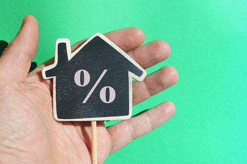 Discount home illustration - house percentage sign price inside a hand- real estate home - money loan symbol.
