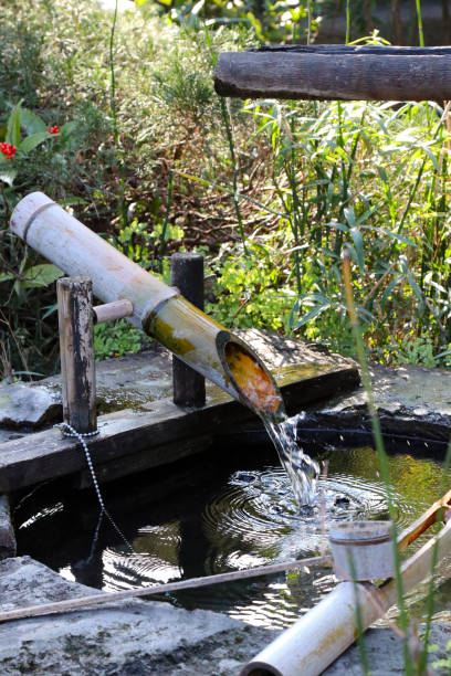 Japanese traditional garden object. Water-filled bamboo tube which clacks against a stone when emptied. stock photo