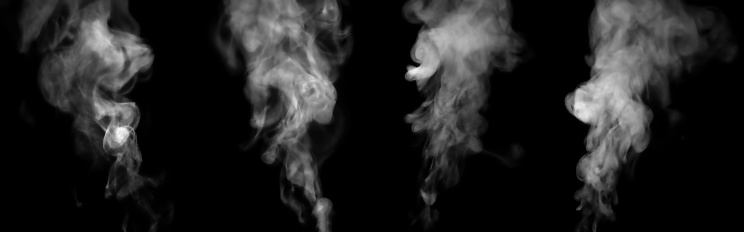 Close-up of steam or abstract white smog rising above. water droplets that can be seen that swirl beautifully. Isolated on a black background