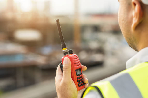 istock Asian engineer handsome man or architect use radio communication with white safety helmet in city construction site . Standing on rooftop building construction at capital. 1364421599