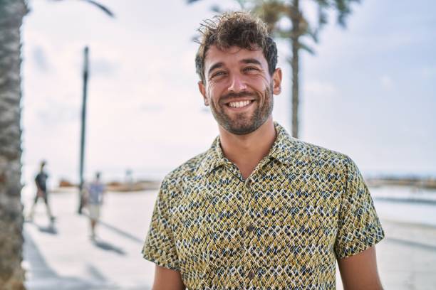 istock Young hispanic man smiling confident walking at seaside 1364423912