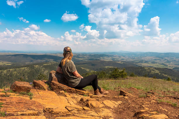 chica turista excursionista descansando en la cima de la montaña y disfrutando de una increíble vista del paisaje de las montañas y el hermoso cielo - tourist photographing armed forces military fotografías e imágenes de stock