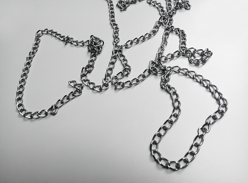 chaotic strands of silver metal chains on a gray background