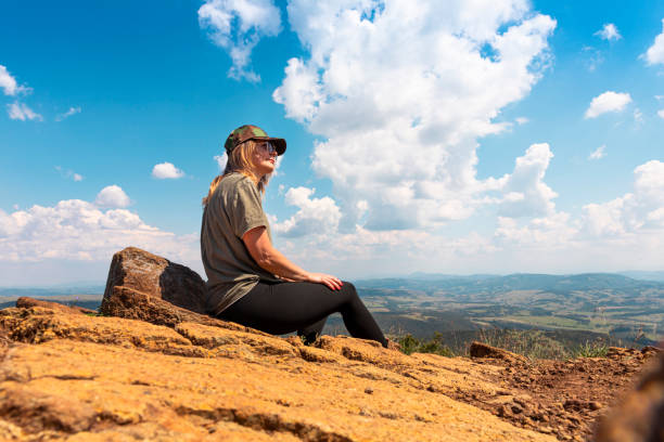 tourist girl hiker resting at the top of the mountain and enjoying amazing landscape view of mountains and beautiful sky - tourist photographing armed forces military imagens e fotografias de stock