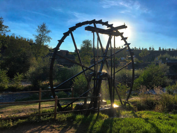 Water Mill with Gremlin in Prague Czechia. Wooden wheel with a lot of spokes is sitting on a wooden platform on a  river