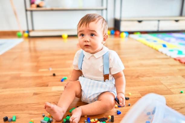 Adorable toddler playing around lots of toys at kindergarten Adorable toddler playing around lots of toys at kindergarten preschool seperationin babies stock pictures, royalty-free photos & images