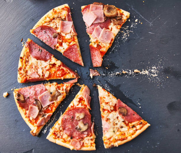 istock Slices of italian pizza on blackboard surface 1364430344