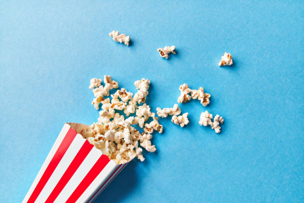 istock Pack of salty popcorns falling on a blue background 1364431281