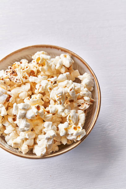 istock Bowl of salty popcorns isolated on a white background 1364431288