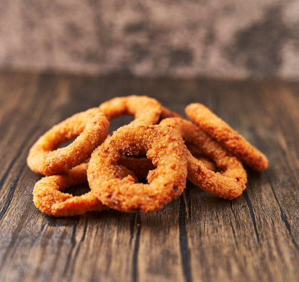 istock Bunch of breaded onion rings on a wooden surface 1364431409