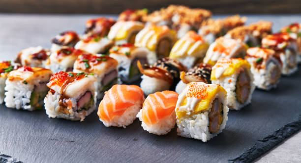istock Group of sushi food rolls on a blackboard surface 1364431482