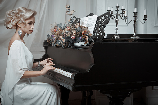 Beautiful young bride playing the piano. Happy wedding.