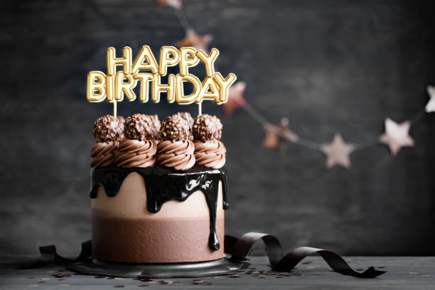 Chocolate birthday cake with  chocolate ganache drip icing and happy birthday banner