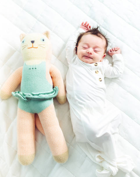 istock Small newborn baby stretching and sleeping on white background with toy 1364433706