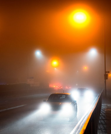 Thick fog creating hazardous driving conditions at night.