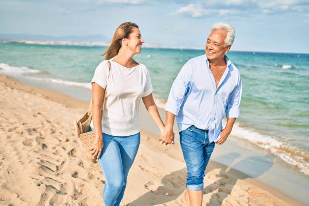 istock Middle age hispanic couple smiling happy walking at the beach. 1364435958