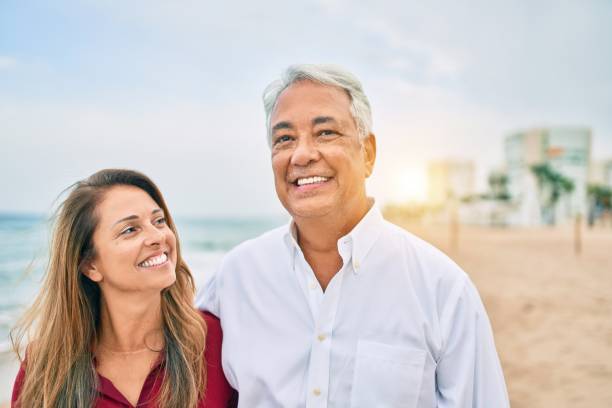 istock Middle age hispanic couple smiling happy walking at the beach. 1364436521