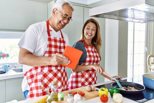 istock Middle age hispanic couple smiling happy cooking and using touchpad at the kitchen. 1364436610