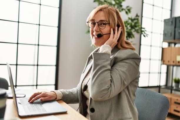 istock Middle age call center agent working at the office. 1364437019