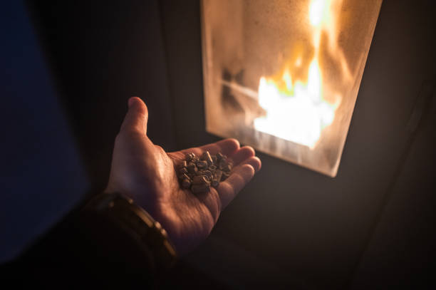 Human hand holding biomass pellets - Biomass Eco Heating stove