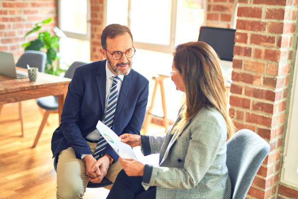 istock Two middle age business workers smiling happy and confident. Working together with smile on face reading documents at the office 1364440696