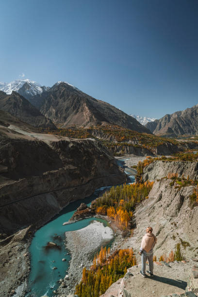 istock Man standing on rock and looking at river in Himalayas 1364442424