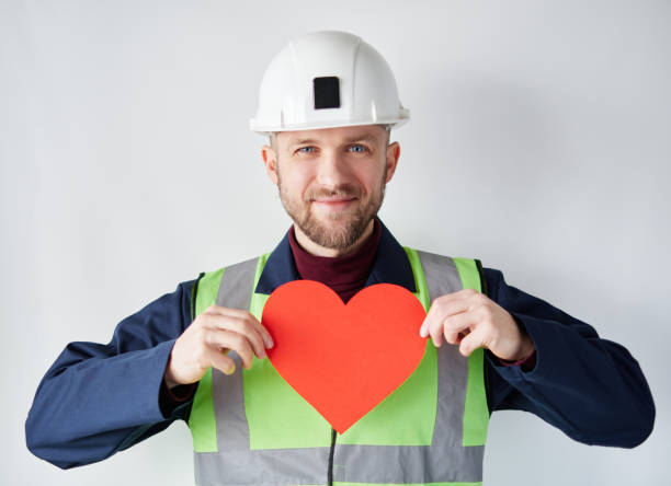 istock Valentine's Day: male worker in hard hat showing red heart 1364442454